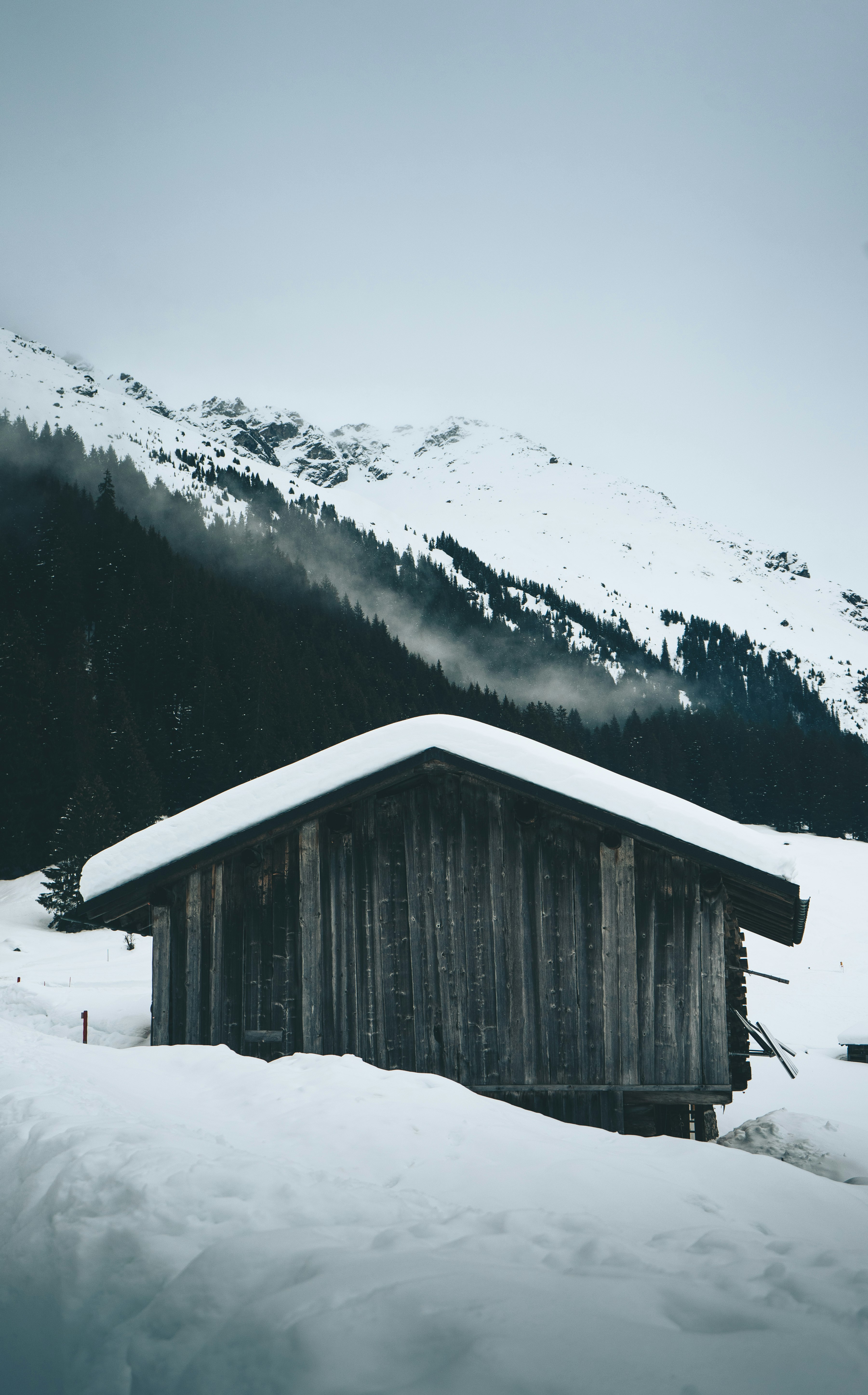 brown wooden house on snow covered ground